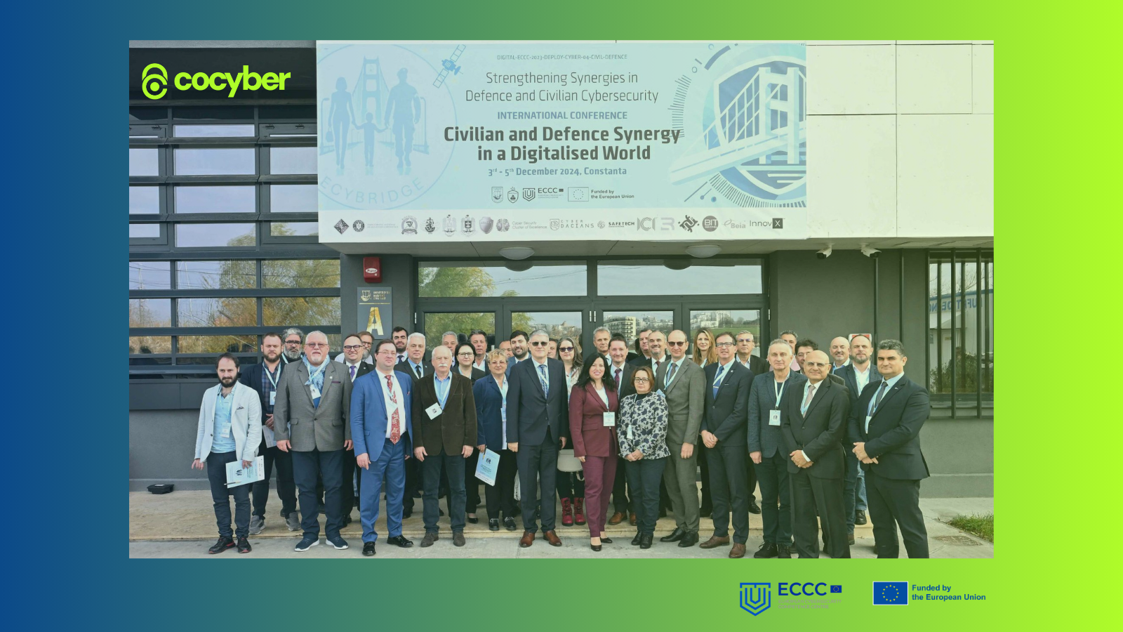 Photo of the conference people in front of the building and banner where it was held